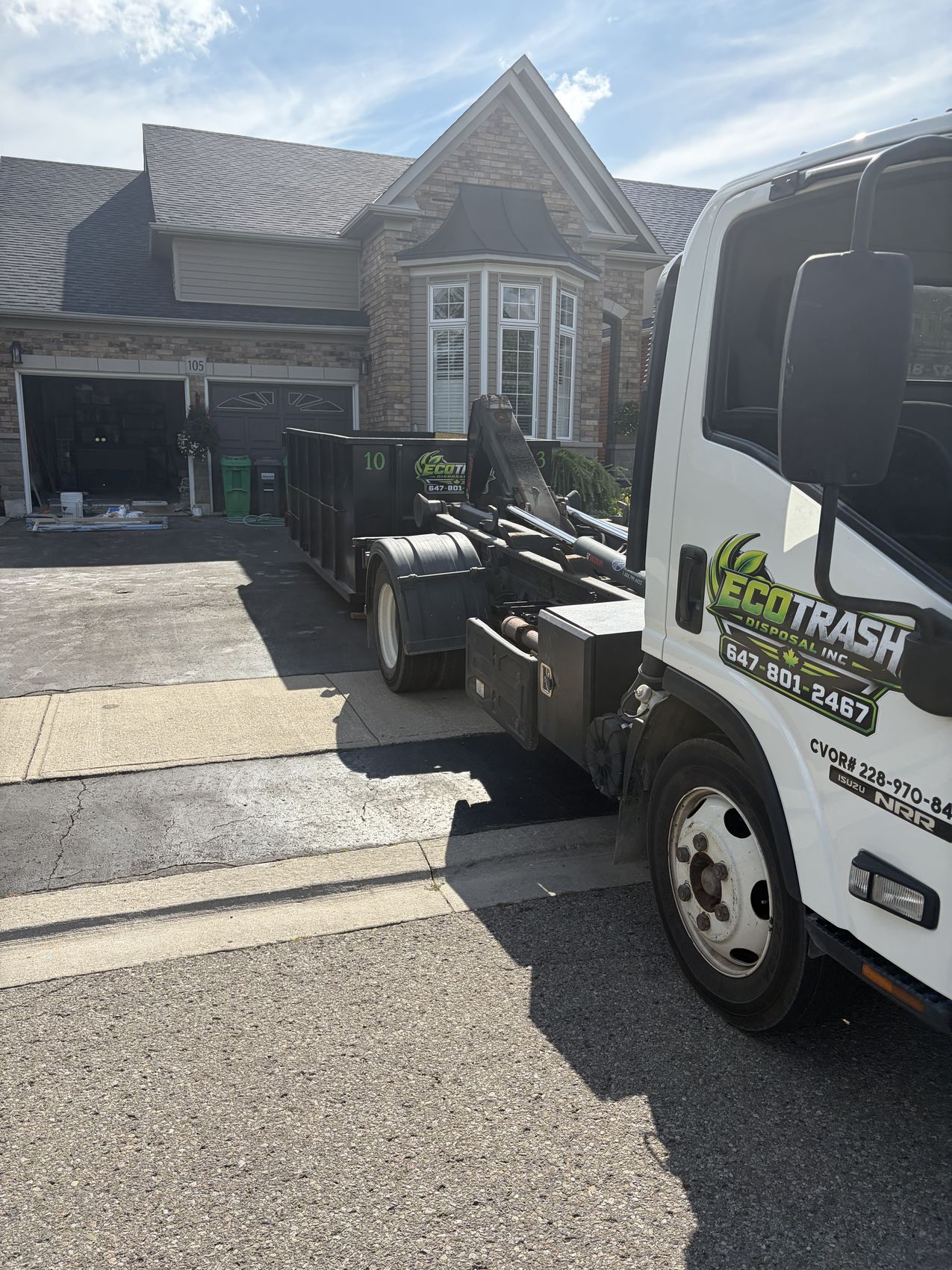 Eco Trash truck setting a bin down on a sunny driveway