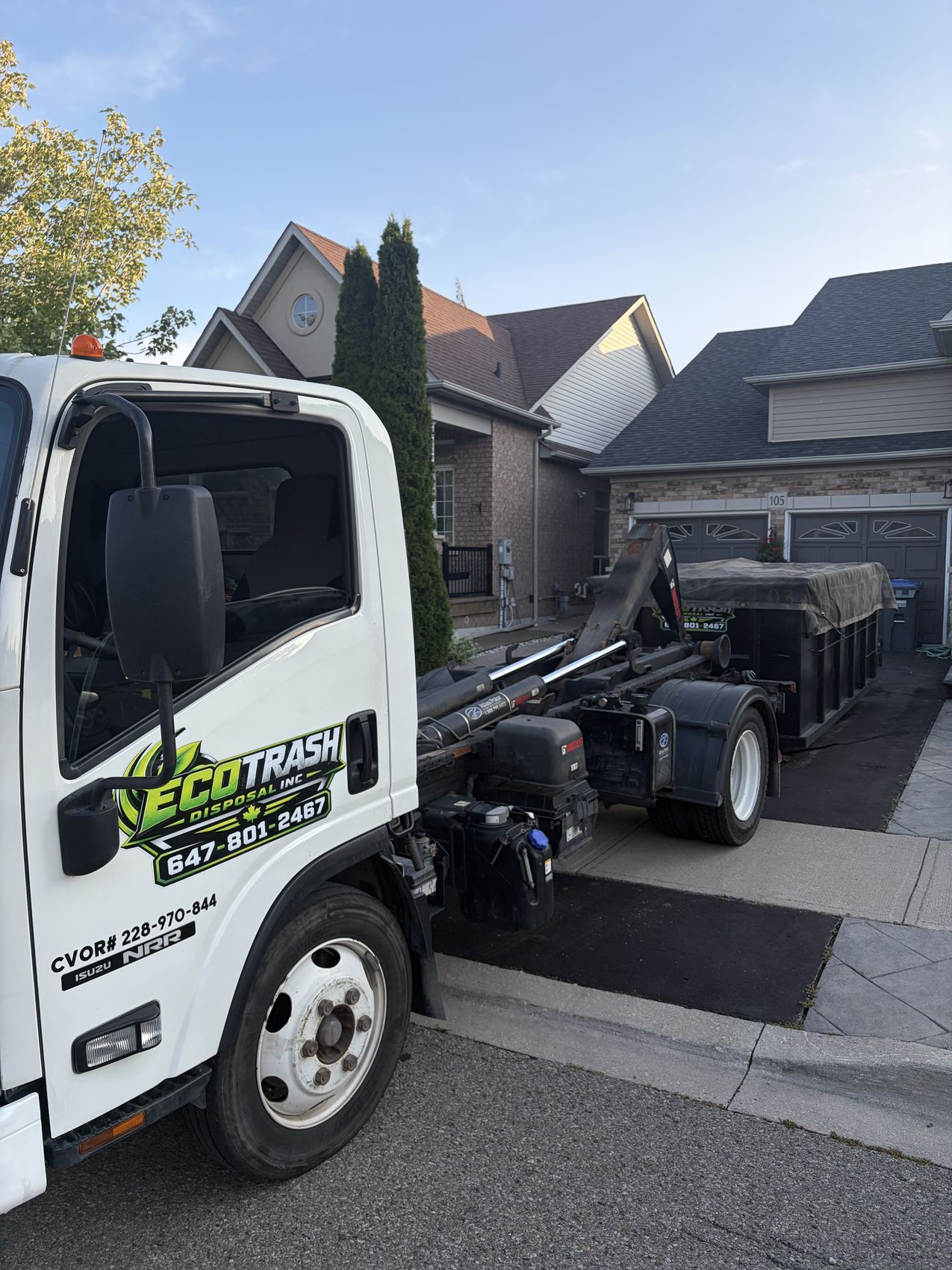 Eco Trash truck collecting a bin at dusk